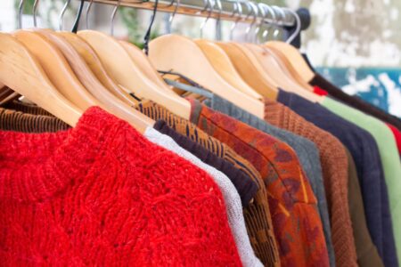 Second hand clothes on hangers for donation and reselling