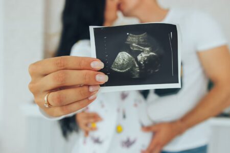 pregnant woman holding her baby ultrasound picture